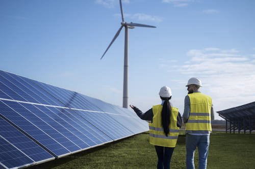 engenheiros ao lado de painel solar