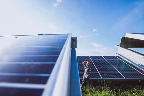 engenheiro em frente a paineis solares olhando para um futuro solar